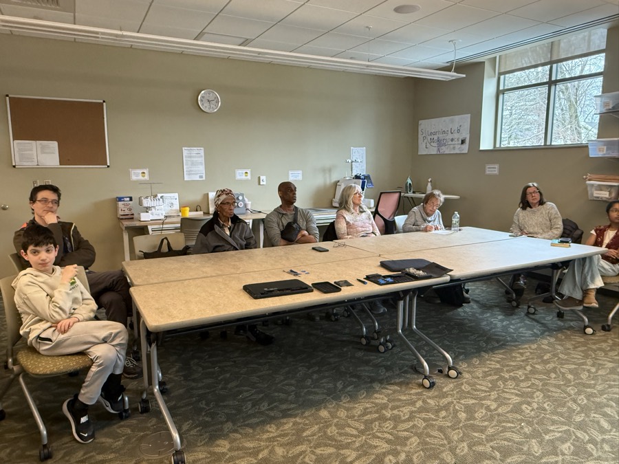 A library meeting room of attendees at the start of a technology workshop